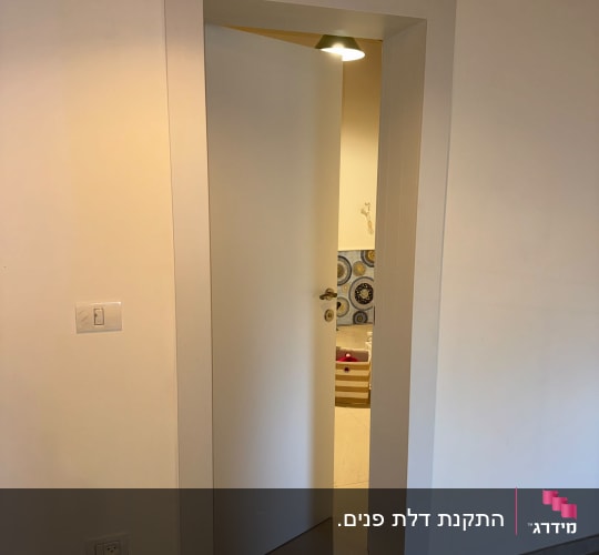 דלת פנים לבנה וחלקה מותקנת עם משקוף תואם